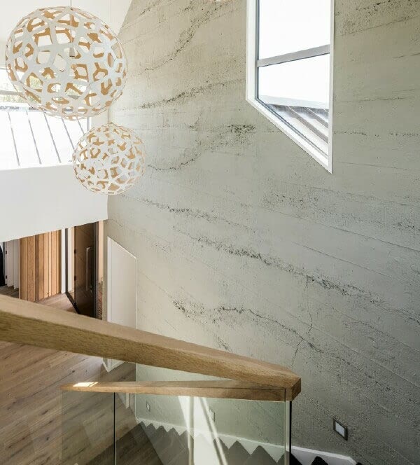 Muros' roughcast concrete wall panels by a staircase in an Auckland property